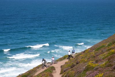 cyclists and walkers on cliff, overlooking the sea