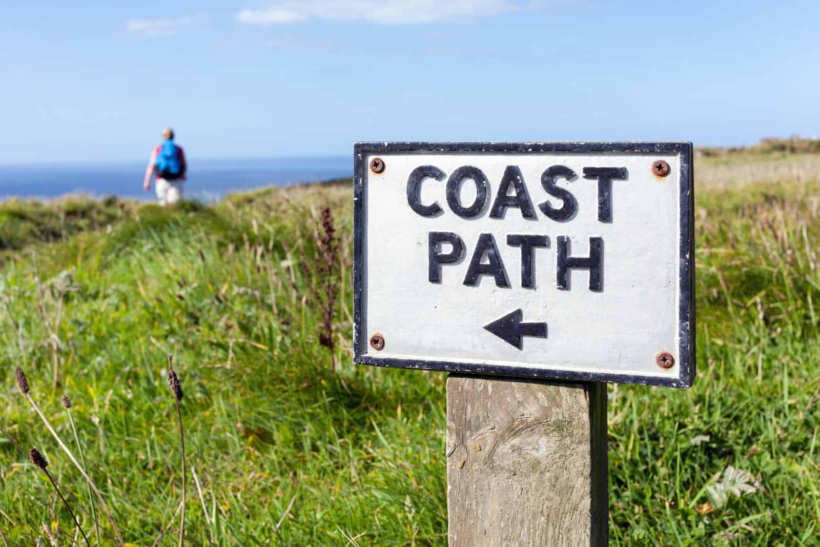 An old coast path sign on the Cornish cliffs near Tintagel, UK.