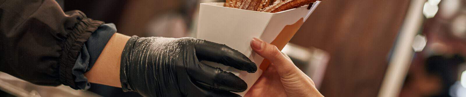 Close-up of person buying churros