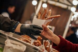 Close-up of person buying churros