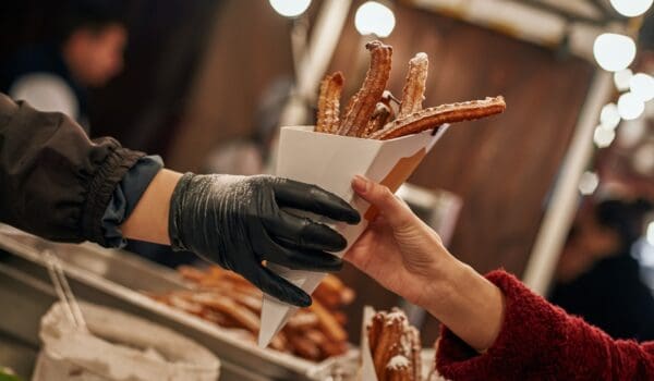 Close-up of person buying churros